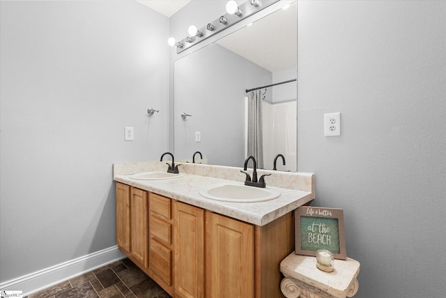 bathroom featuring double vanity, baseboards, curtained shower, and a sink