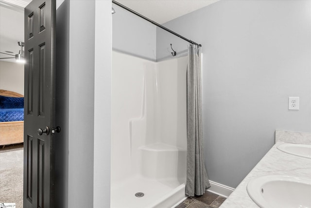 bathroom with baseboards, a sink, and a stall shower