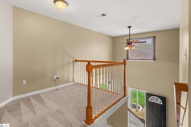 interior space featuring carpet flooring, baseboards, visible vents, and ceiling fan
