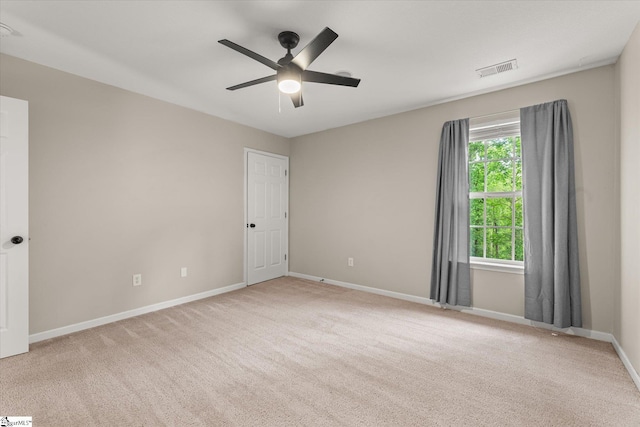 spare room featuring ceiling fan, visible vents, baseboards, and carpet