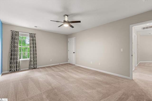 unfurnished room featuring baseboards, carpet, a ceiling fan, and visible vents