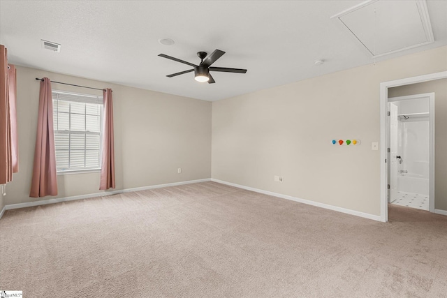 spare room with ceiling fan, carpet floors, attic access, baseboards, and visible vents