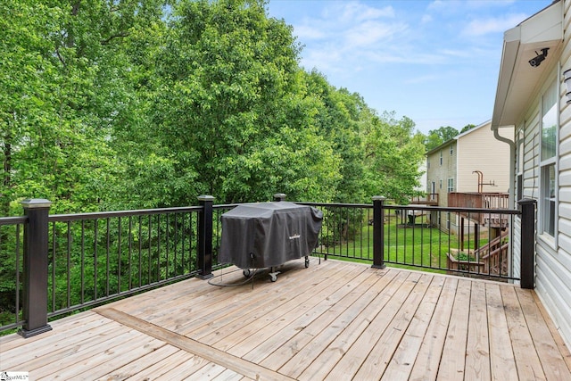 wooden deck featuring a yard and area for grilling