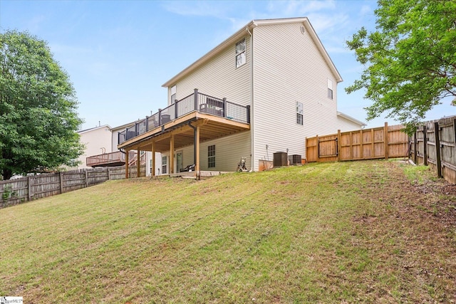 rear view of house with a fenced backyard, a wooden deck, a lawn, and cooling unit