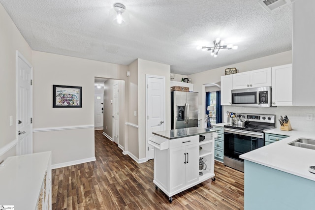 kitchen featuring open shelves, appliances with stainless steel finishes, dark wood finished floors, white cabinetry, and visible vents