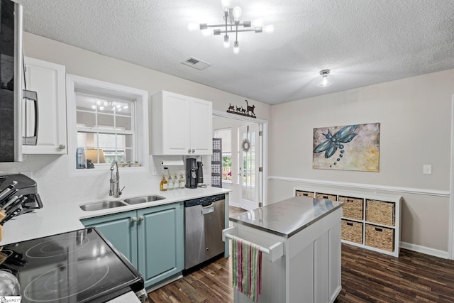 kitchen featuring a sink, stainless steel dishwasher, dark wood finished floors, and visible vents