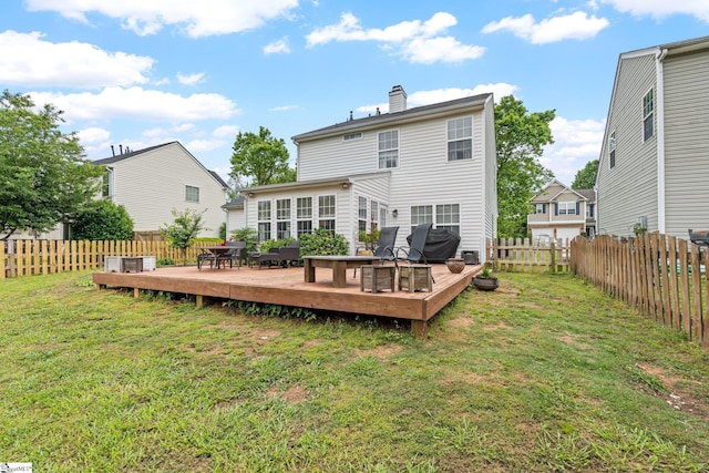 rear view of house with a lawn, a chimney, a fenced backyard, and a wooden deck