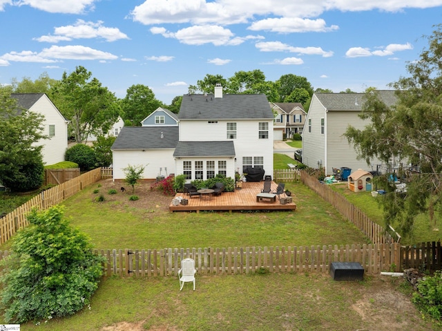 back of house featuring a lawn, a wooden deck, a chimney, and a fenced backyard