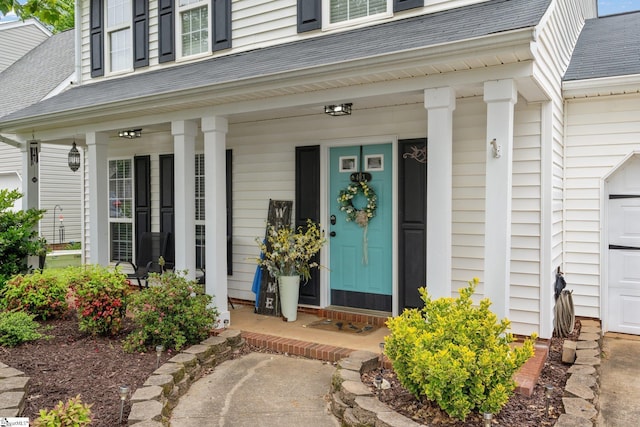 property entrance with a shingled roof and covered porch