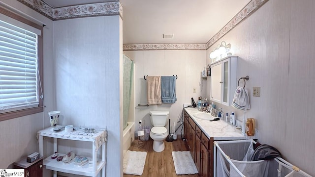 bathroom with vanity, visible vents, wood finished floors, toilet, and shower / bathtub combination with curtain