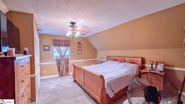 bedroom with a ceiling fan, a textured ceiling, vaulted ceiling, baseboards, and light carpet
