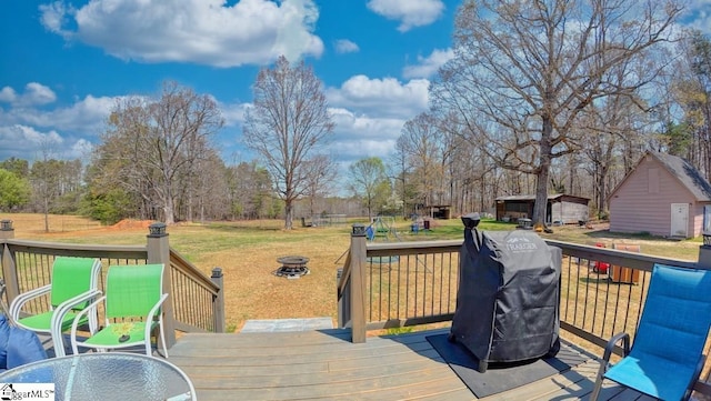 wooden terrace featuring a yard and grilling area