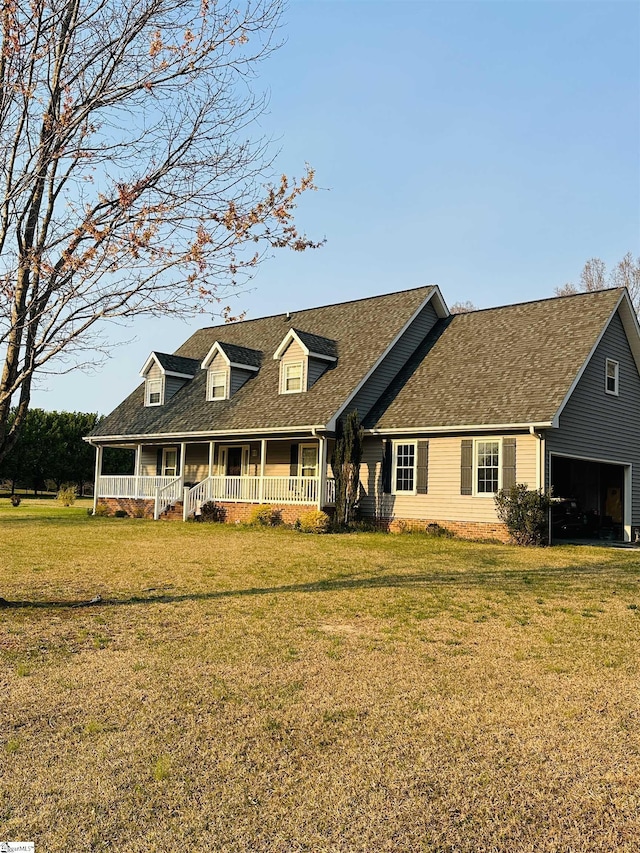 cape cod house featuring roof with shingles, covered porch, and a front lawn