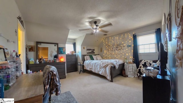 carpeted bedroom with a ceiling fan, a textured ceiling, and vaulted ceiling