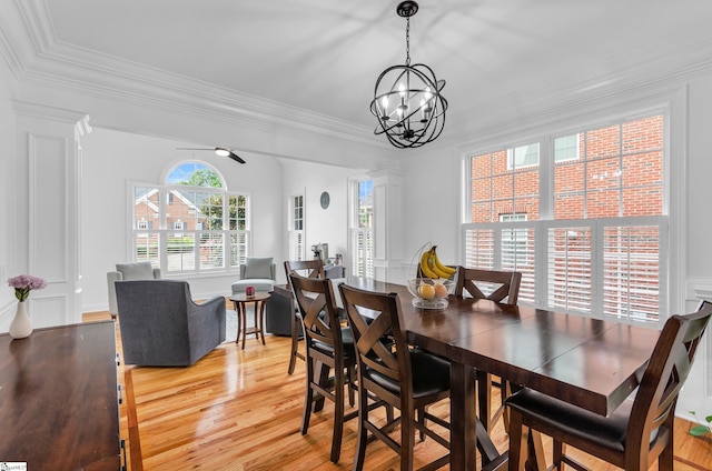 dining room with crown molding, light wood-style floors, and a chandelier