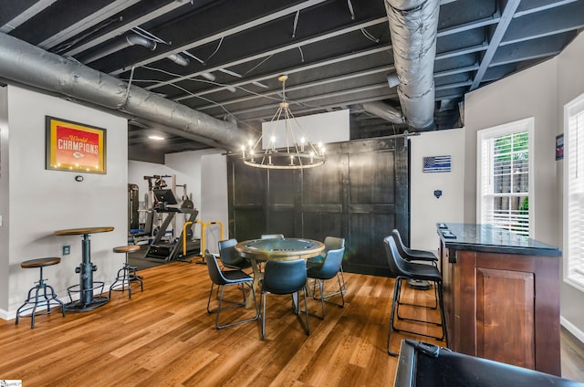 dining space with wood finished floors and a chandelier