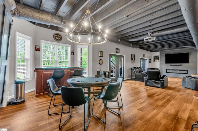 dining area featuring baseboards, a notable chandelier, wood finished floors, and a wealth of natural light