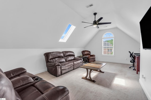 living area with visible vents, carpet floors, baseboards, lofted ceiling with skylight, and a ceiling fan