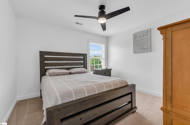 bedroom with visible vents, baseboards, ceiling fan, and light colored carpet