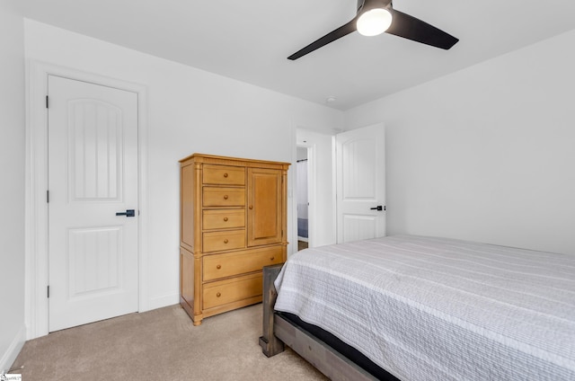bedroom with light colored carpet and a ceiling fan