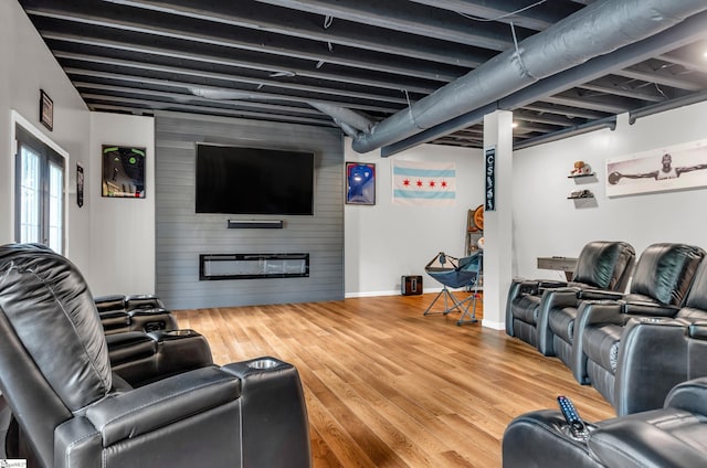 living area with baseboards, an accent wall, wood finished floors, and wooden walls