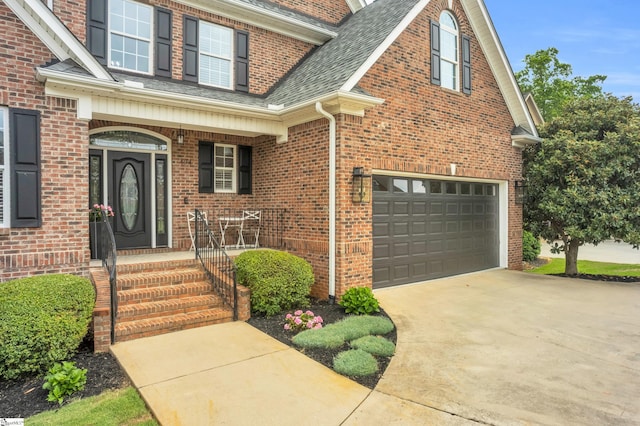 entrance to property featuring a porch, driveway, brick siding, an attached garage, and a shingled roof