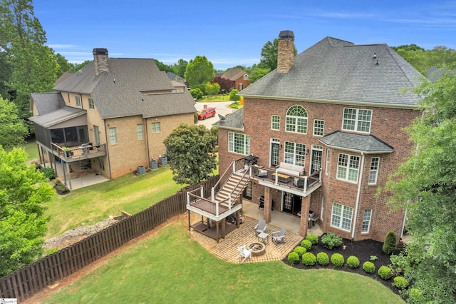 back of property featuring stairs, brick siding, a wooden deck, a chimney, and a patio area