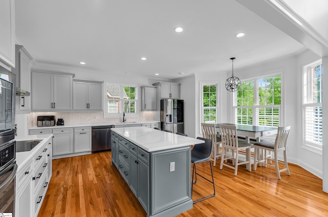 kitchen featuring stainless steel appliances, a sink, plenty of natural light, and gray cabinets