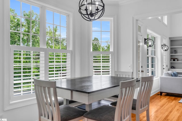 dining room featuring crown molding, light wood finished floors, and a chandelier