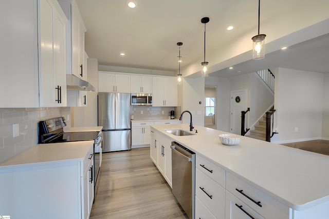 38 Comanche Trl, Greenville, SC 29607 - kitchen with decorative backsplash, a sink, white cabinets, under cabinet range hood, and stainless steel appliances