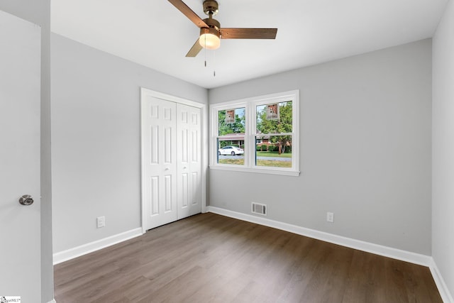 unfurnished bedroom with baseboards, wood finished floors, and visible vents