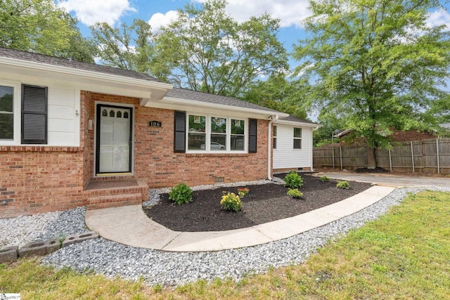 ranch-style house with crawl space, brick siding, fence, and roof with shingles