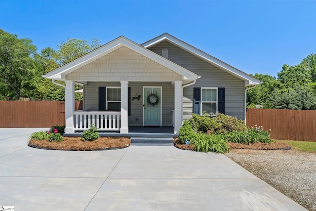 bungalow-style home with fence and a porch