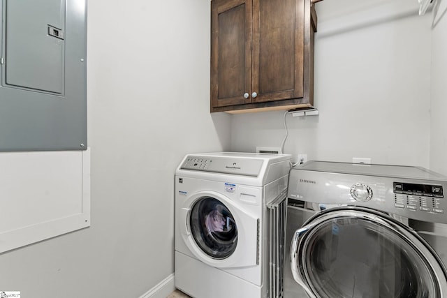 clothes washing area with electric panel, cabinet space, and washing machine and clothes dryer