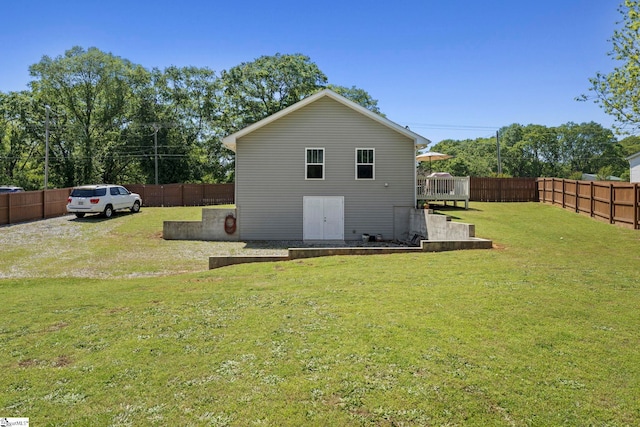view of side of property with a lawn, a fenced backyard, and a deck