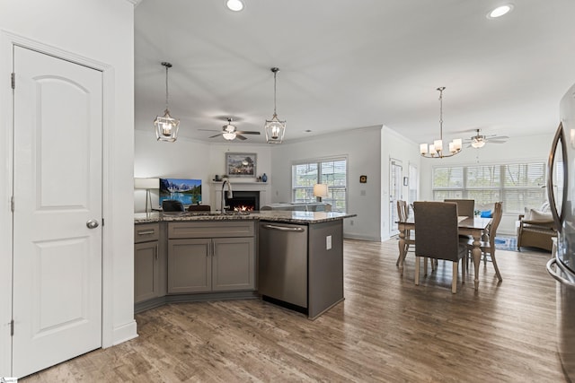 305 Fox Brook Ct, Taylors, SC 29687 - kitchen with ceiling fan with notable chandelier, open floor plan, a warm lit fireplace, recessed lighting, and appliances with stainless steel finishes