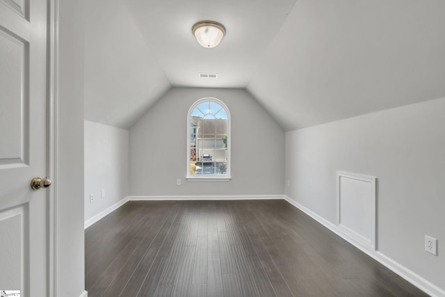 bonus room featuring visible vents, baseboards, lofted ceiling, and dark wood-style floors