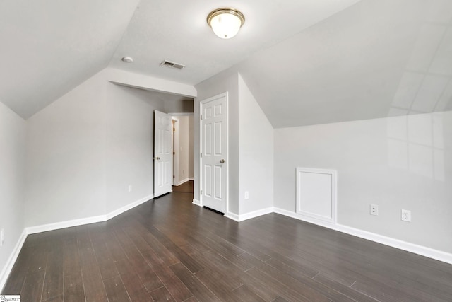 additional living space featuring visible vents, baseboards, dark wood finished floors, and lofted ceiling