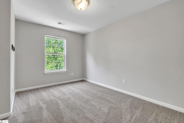 carpeted empty room featuring visible vents and baseboards