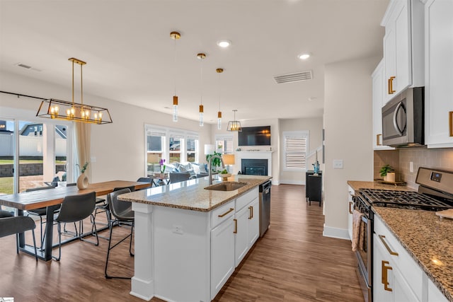 kitchen featuring a sink, stainless steel appliances, open floor plan, and visible vents