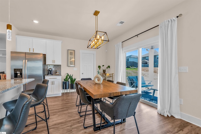 dining room featuring an inviting chandelier, light wood finished floors, recessed lighting, baseboards, and visible vents