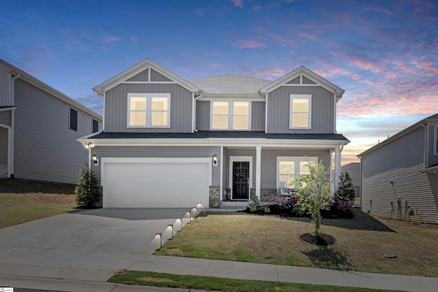 view of front of property with a porch, board and batten siding, a garage, a yard, and concrete driveway