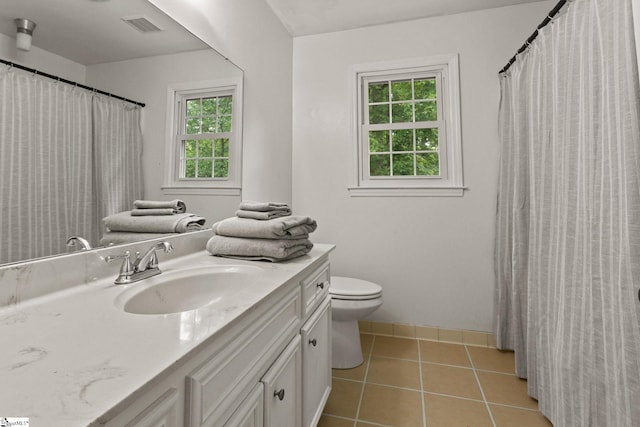 bathroom with visible vents, vanity, toilet, baseboards, and tile patterned floors