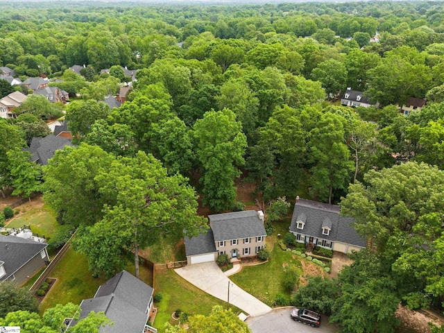 drone / aerial view featuring a residential view and a forest view