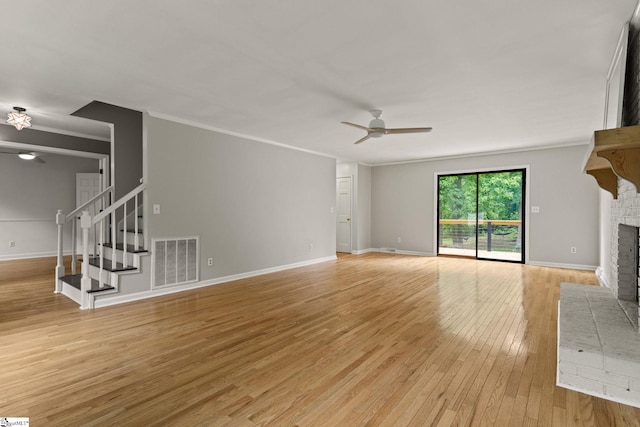 unfurnished living room with ceiling fan, visible vents, light wood finished floors, and a fireplace