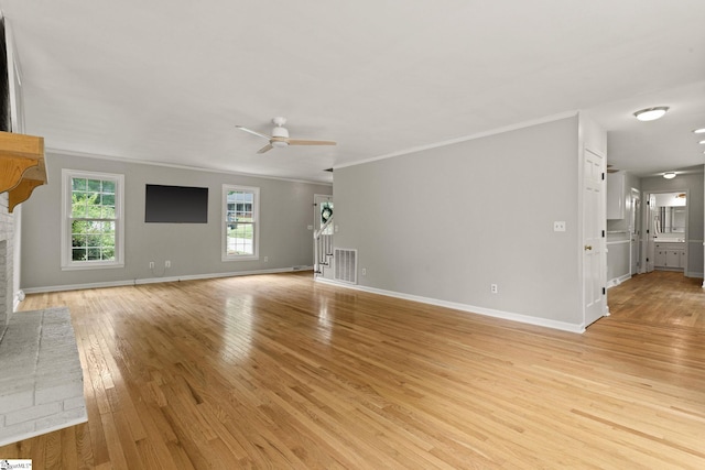 unfurnished living room with visible vents, light wood-style flooring, crown molding, and ceiling fan