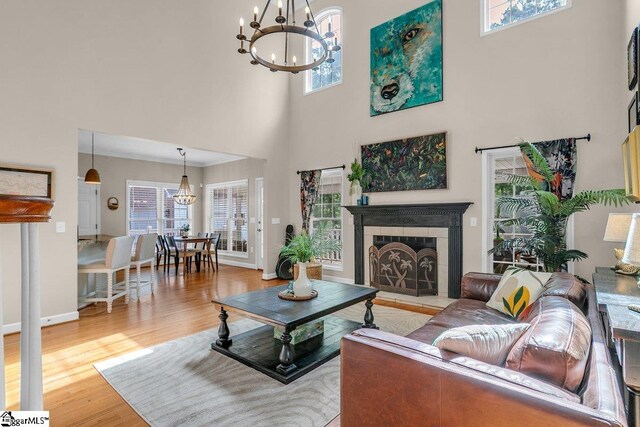 268 Antrim Ave, Moore, SC 29369 - living room with a high ceiling, an inviting chandelier, a tiled fireplace, baseboards, and wood finished floors