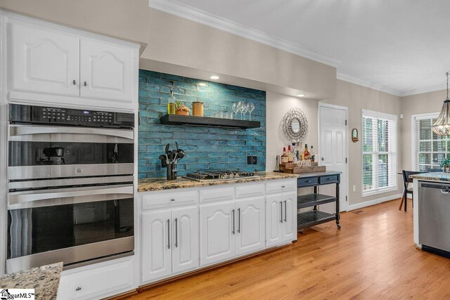 268 Antrim Ave, Moore, SC 29369 - kitchen featuring appliances with stainless steel finishes, light stone countertops, white cabinets, ornamental molding, and light wood-style flooring