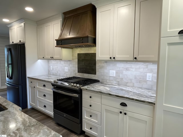 kitchen featuring gas stove, white cabinetry, recessed lighting, custom range hood, and black fridge with ice dispenser