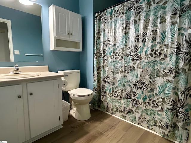 full bath with vanity, a shower with curtain, toilet, and wood finished floors